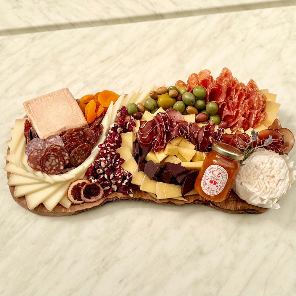 Medium Cheese Platter with cheese, meat, olives, nuts, dried fruit, chocolate, preserve on a wood carving board